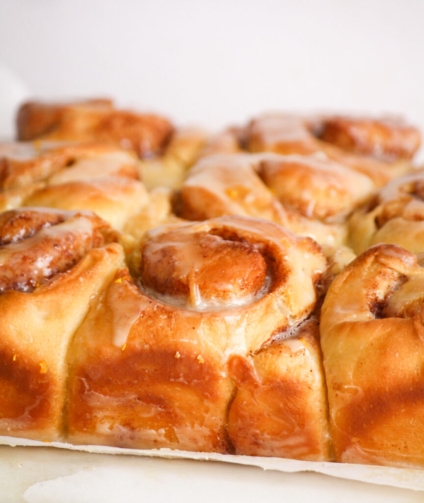 Fluffy eggless cinnamon rolls made with fresh orange, topped with an orange glaze!