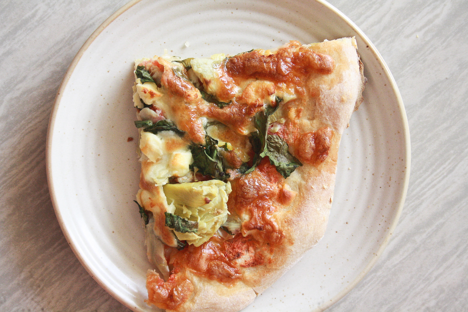 A chewy, deeply flavoured pizza crust topped with a simple tomato sauce, spinach and artichokes, plus lots of cheese!