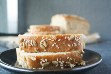 Soft and chewy homemade rye bread topped with sesame and sunflower seeds.