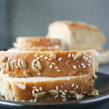 Soft and chewy homemade rye bread topped with sesame and sunflower seeds.