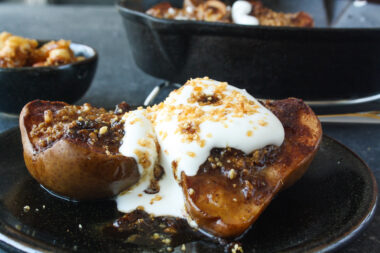 Soft, juicy, spiced baked pears stuffed with hazelnut praline and topped with cream!