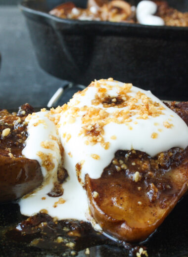 Soft, juicy, spiced baked pears stuffed with hazelnut praline and topped with cream!