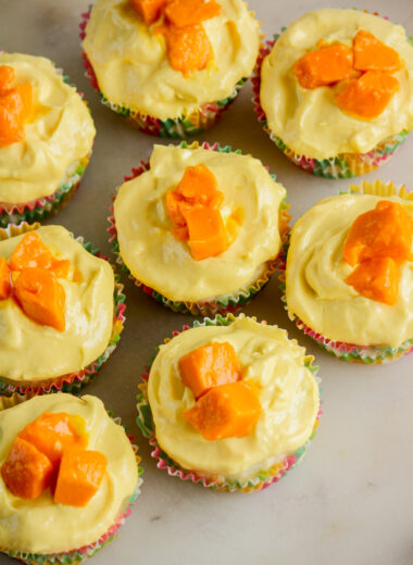 Soft, moist cupcakes with coconut, topped with a mango cream cheese frosting