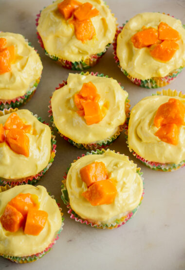 Soft, moist cupcakes with coconut, topped with a mango cream cheese frosting
