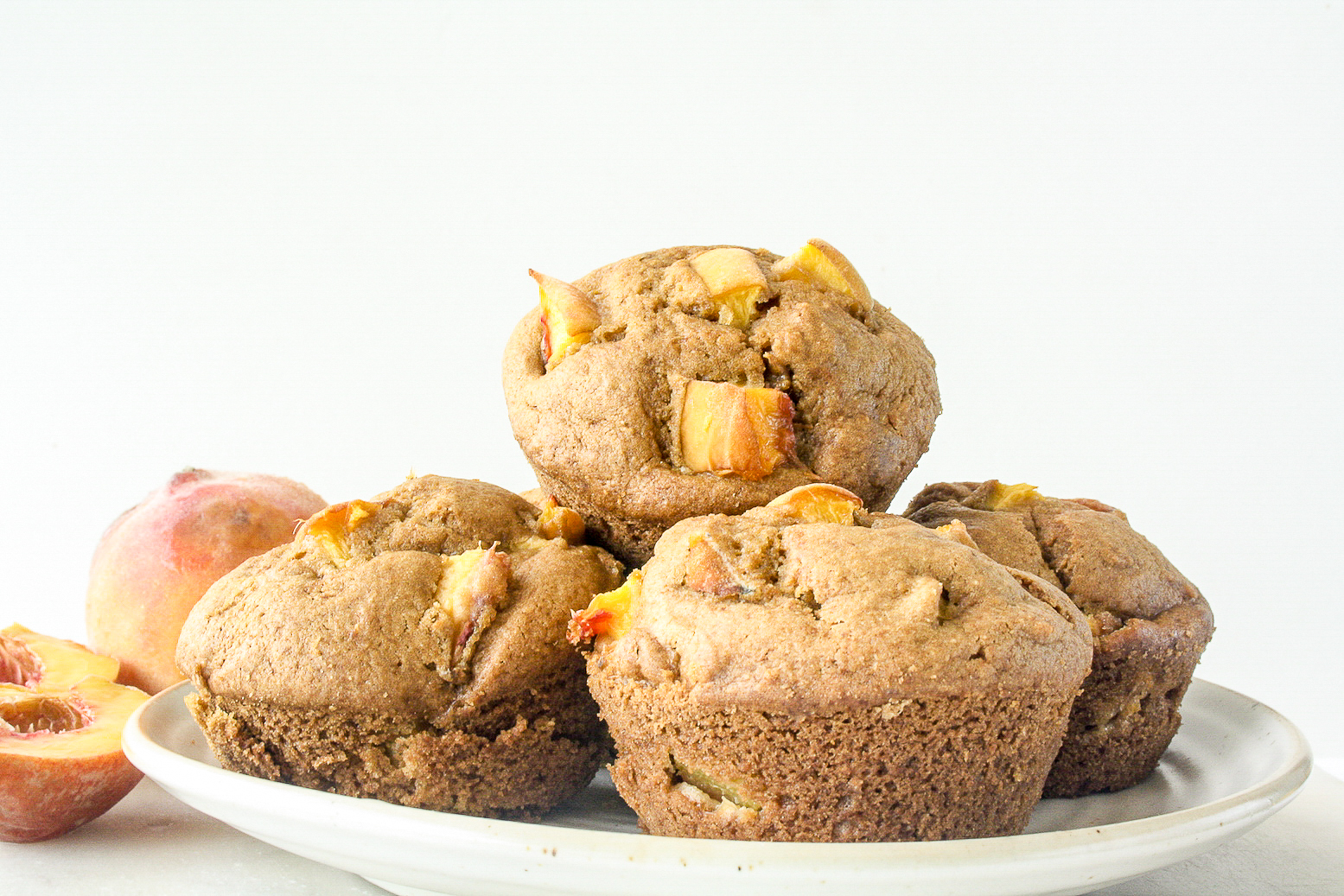 Tender brown sugar muffins made with cornmeal and fresh peaches!