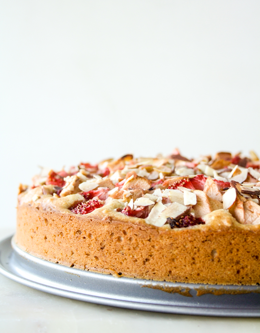 Tender almond and browned butter cake topped with fresh apples and strawberries