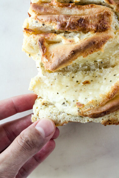 A soft and buttery pull-apart bread with a garlicky cream cheese and cheddar filling!