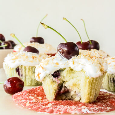 Mini coconut and fresh cherry cakes with whipped cream and toasted coconut topping