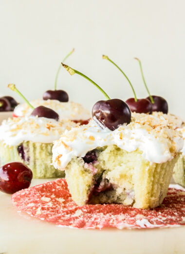 Mini coconut and fresh cherry cakes with whipped cream and toasted coconut topping