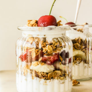 Crunchy vegan, gluten-free date and almond granola with yoghurt, bananas and cherries