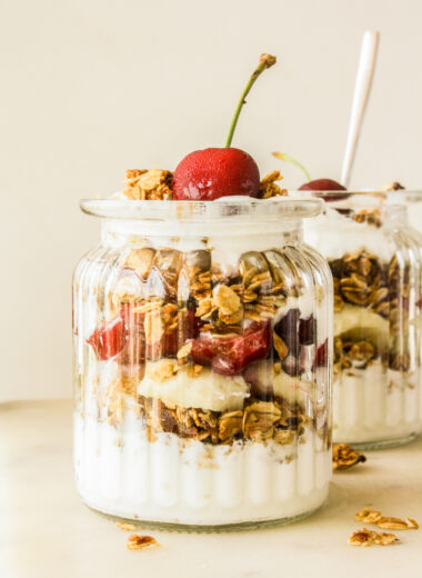 Crunchy vegan, gluten-free date and almond granola with yoghurt, bananas and cherries