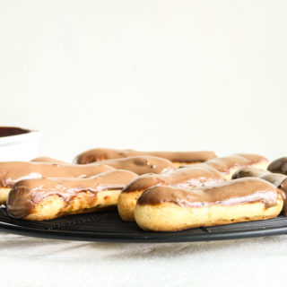 Eclairs with homemade choux pastry, filled with whipped cream and topped with chocolate ganache