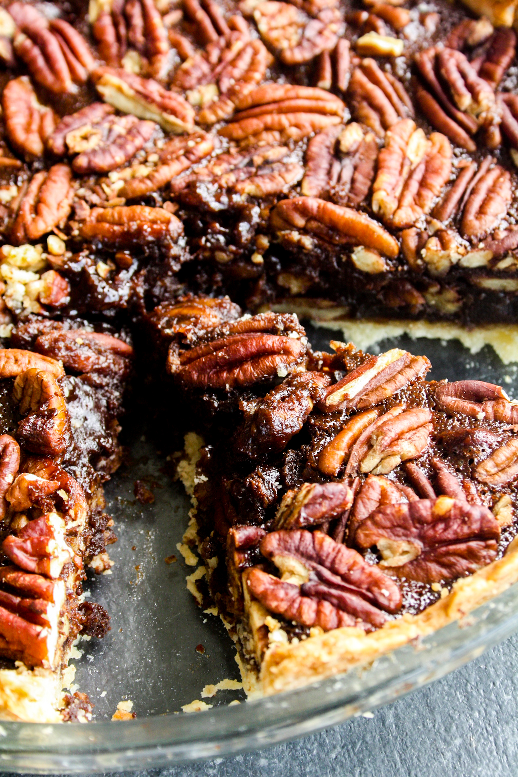 Rich and gooey dark chocolate pecan pie made with honey not corn syrup, on a homemade flaky pie crust