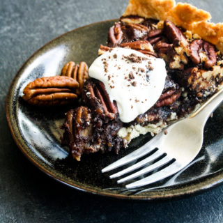 Rich and gooey dark chocolate pecan pie made with honey not corn syrup, on a homemade flaky pie crust