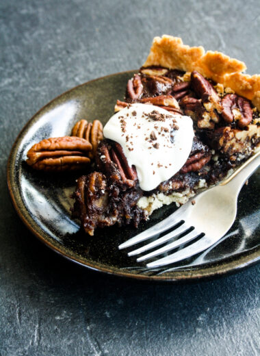 Rich and gooey dark chocolate pecan pie made with honey not corn syrup, on a homemade flaky pie crust