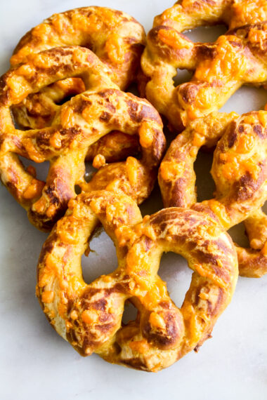 Soft and chewy homemade pretzels with orange cheddar and garlic