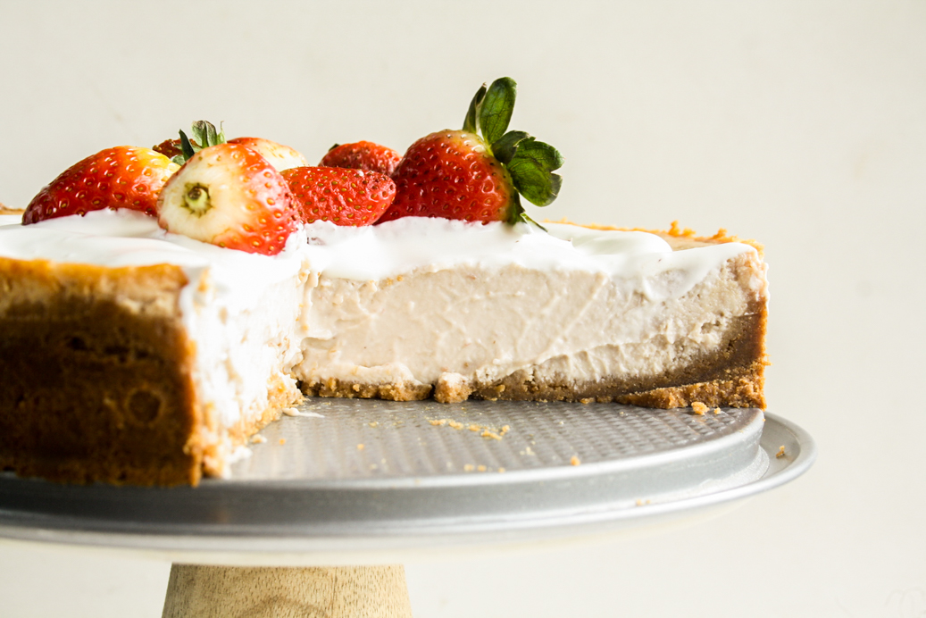Smooth, creamy baked cheesecake with strawberries in the filling and on top!