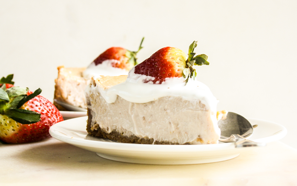 Smooth, creamy baked cheesecake with strawberries in the filling and on top!