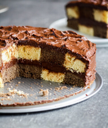Buttery chocolate and vanilla cake assembled in a checkered pattern with a thick, fudgy chocolate frosting