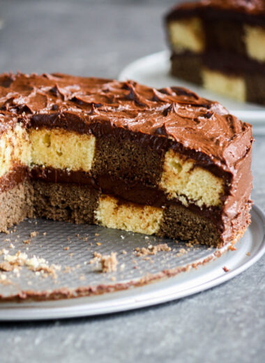 Buttery chocolate and vanilla cake assembled in a checkered pattern with a thick, fudgy chocolate frosting