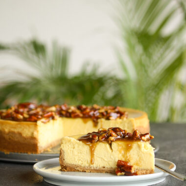 Creamy baked cheesecake with homemade pumpkin puree with a roasted pecan and caramel topping