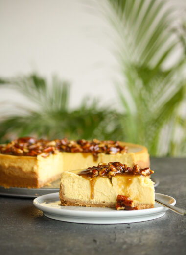 Creamy baked cheesecake with homemade pumpkin puree with a roasted pecan and caramel topping