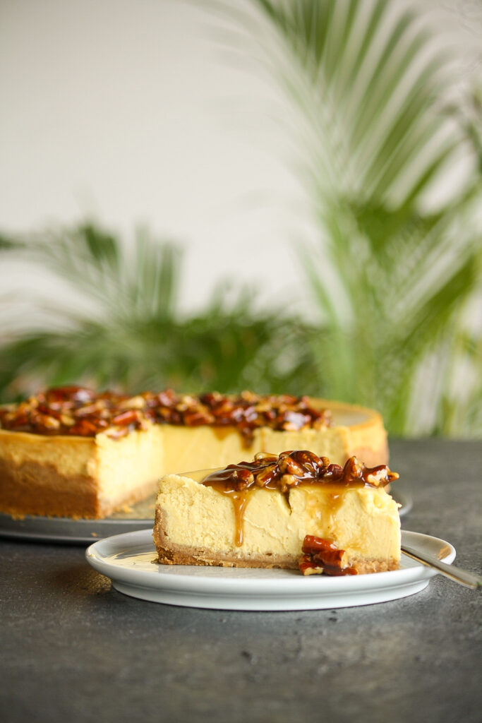 Creamy baked cheesecake with homemade pumpkin puree with a roasted pecan and caramel topping