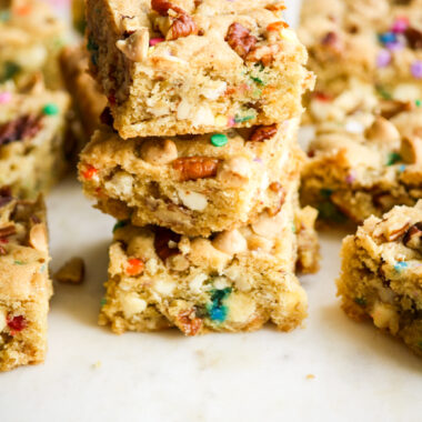 Chewy, buttery cookie bars with toasted pecans, white chocolate chips and rainbow sprinkles!