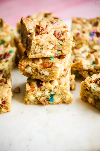 Chewy, buttery cookie bars with toasted pecans, white chocolate chips and rainbow sprinkles!
