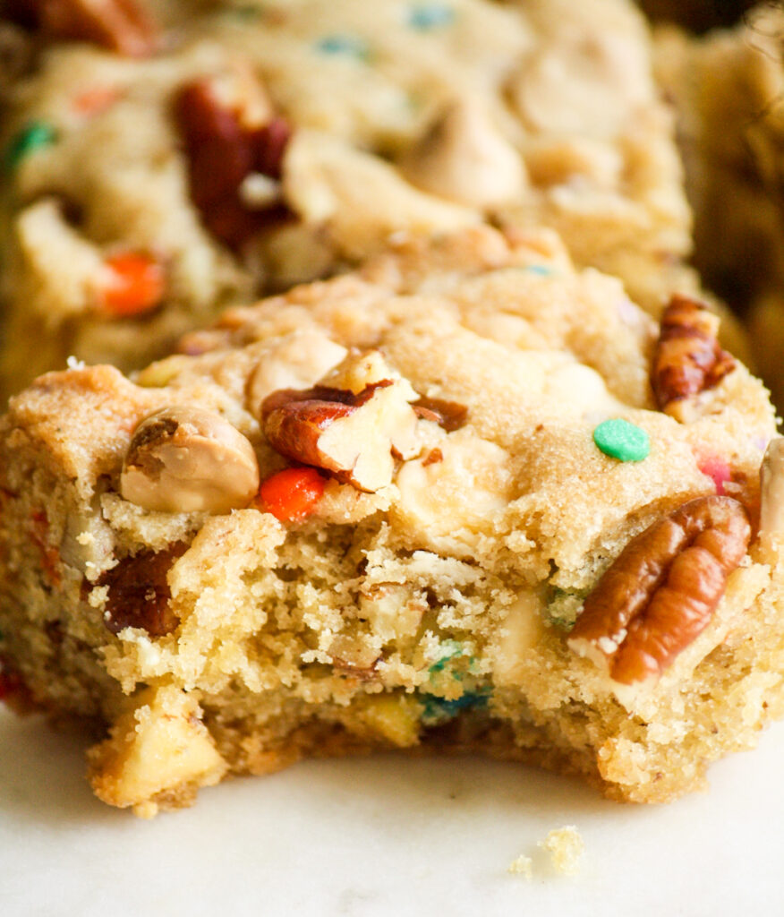 Chewy, buttery cookie bars with toasted pecans, white chocolate chips and rainbow sprinkles!