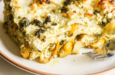 Roasted zucchini and pesto lasagna layered with cream cheese sauce and topped with feta