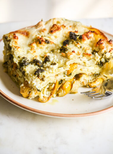 Roasted zucchini and pesto lasagna layered with cream cheese sauce and topped with feta