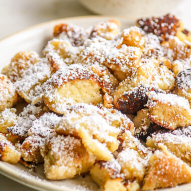 Soft, fluffy pancake cut into pieces and served with icing sugar and an easy plum sauce