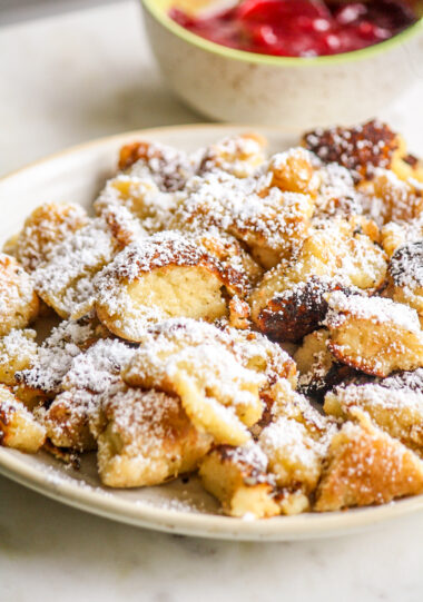Soft, fluffy pancake cut into pieces and served with icing sugar and an easy plum sauce