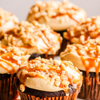Dark chocolate cupcakes with peanut butter frosting, salted caramel and chopped roasted peanuts
