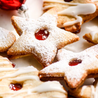 Christmas cookies with ground almonds, filled with strawberry jam and topped with lemon glaze or powdered sugar!