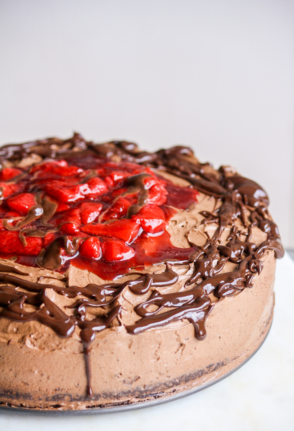 Simple chocolate cake layered with roasted strawberries and whipped ganache frosting