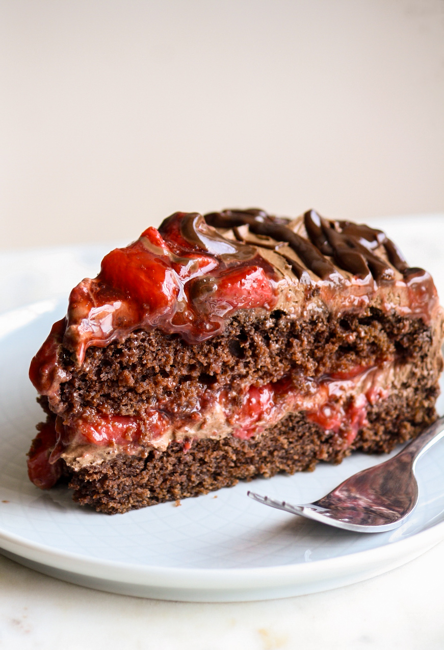 Simple chocolate cake layered with roasted strawberries and whipped ganache frosting