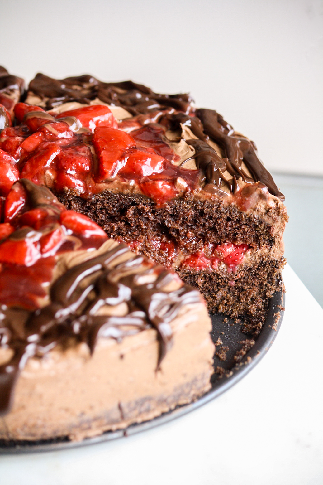 Simple chocolate cake layered with roasted strawberries and whipped ganache frosting