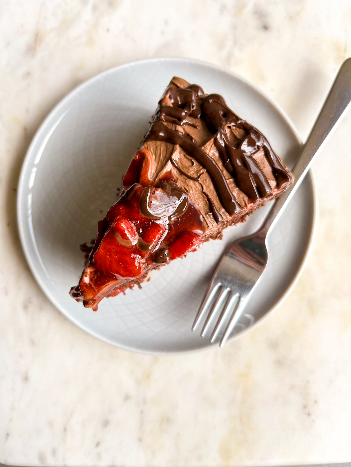 Simple chocolate cake layered with roasted strawberries and whipped ganache frosting