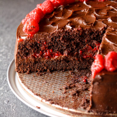 A rich and fudgy chocolate cake layered with dark chocolate ganache and filled with an easy raspberry filling