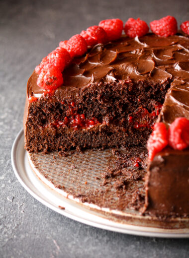 A rich and fudgy chocolate cake layered with dark chocolate ganache and filled with an easy raspberry filling